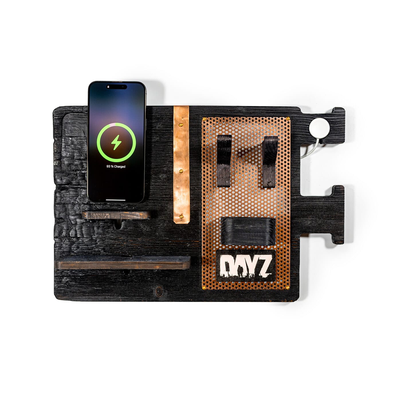 DayZ stojánek shora. IPhone na MagSafe nabíječce, perforovaný měděný panel s logem